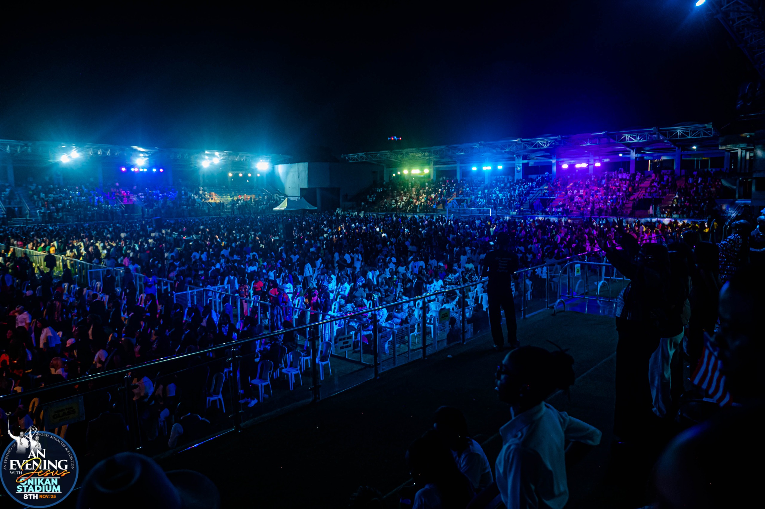 A packed Onikan Stadium crowd under the night lights